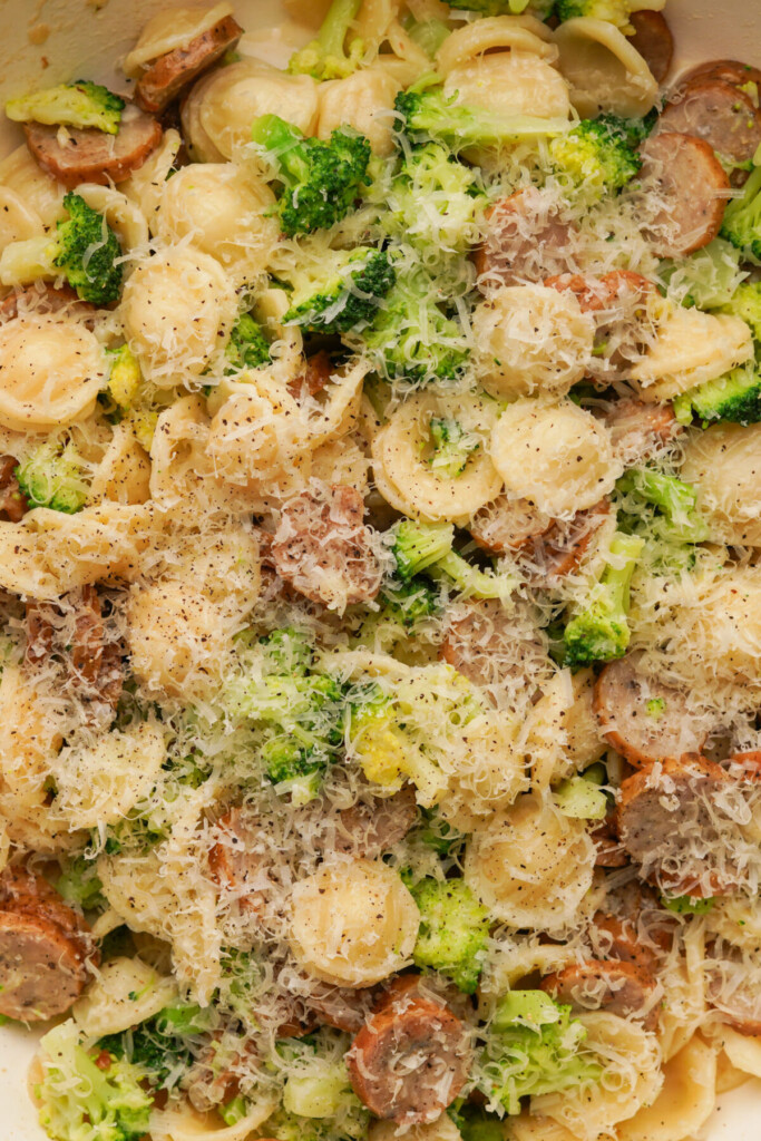 a close up photo on broccoli sausage pasta with parmesan on top