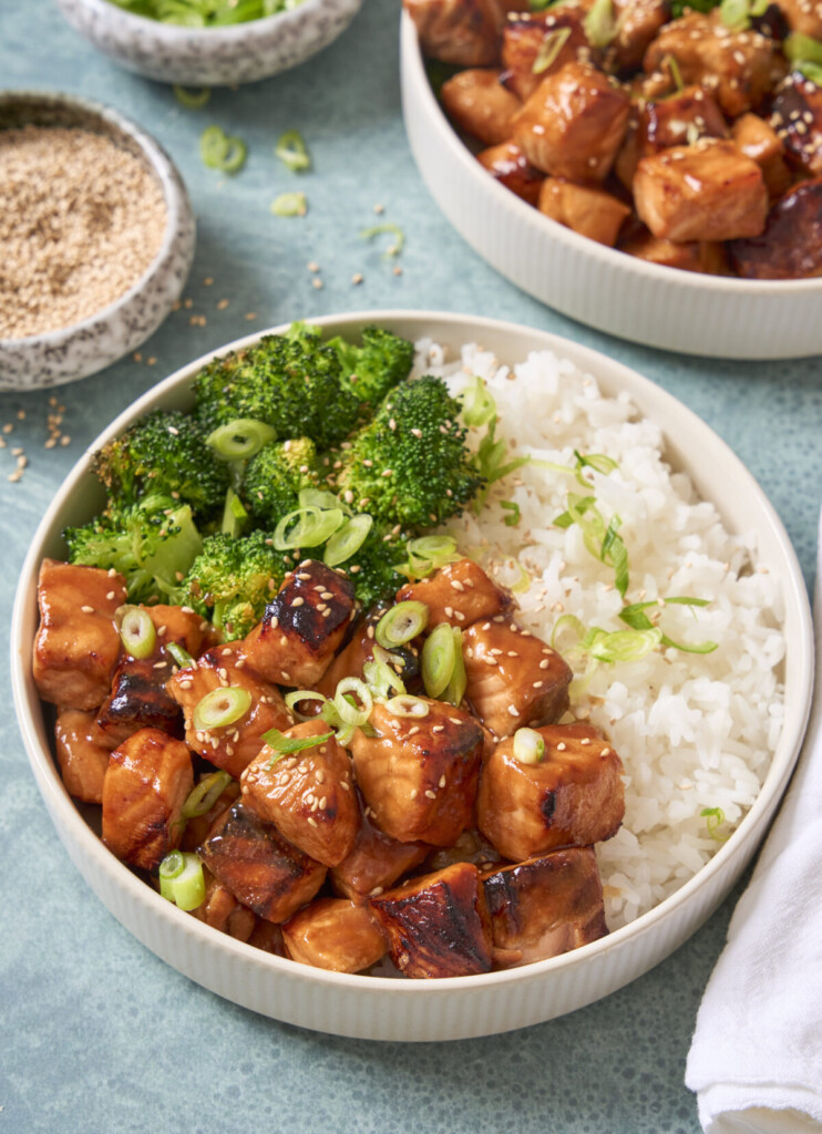 a three quarter view photo of salmon bites in a bowl with rice and broccoli