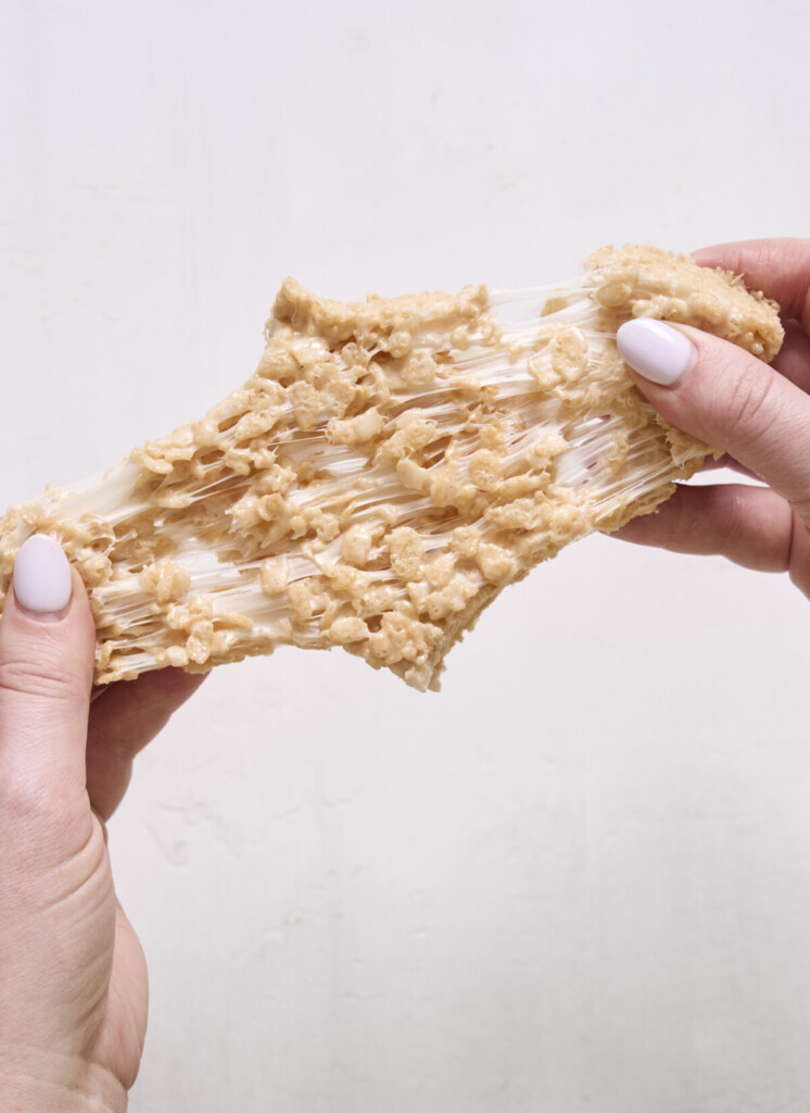 a photo of hands pulling apart a rice krispie treat