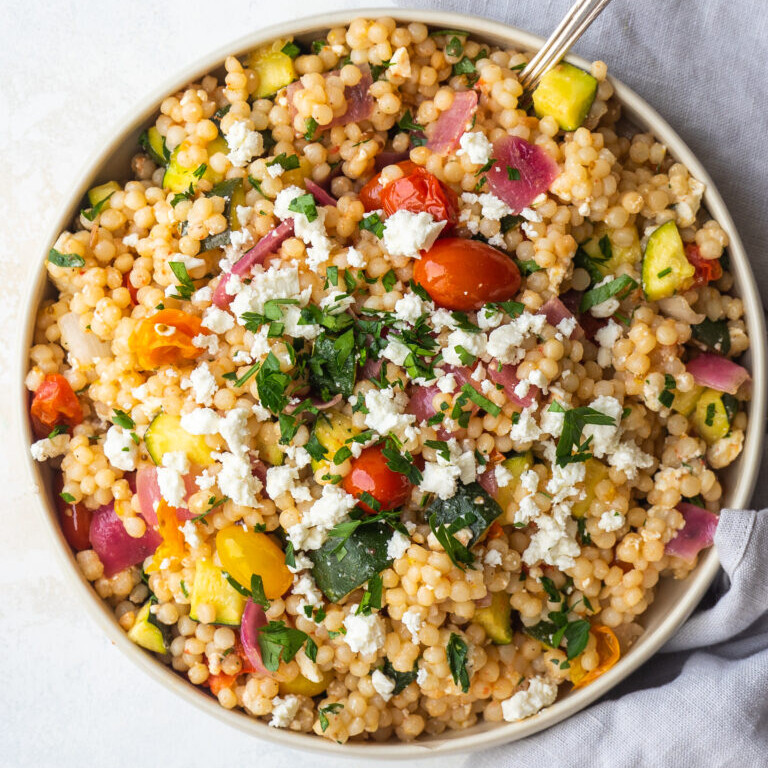 an above view photo of veggie couscous salad in a white bowl