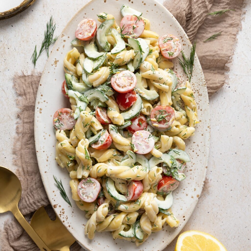 an above view image of cucumber pasta salad on an oval platter