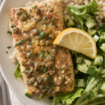 a close up photo of air fryer halibut with vegetables next to it and a lemon slice on top