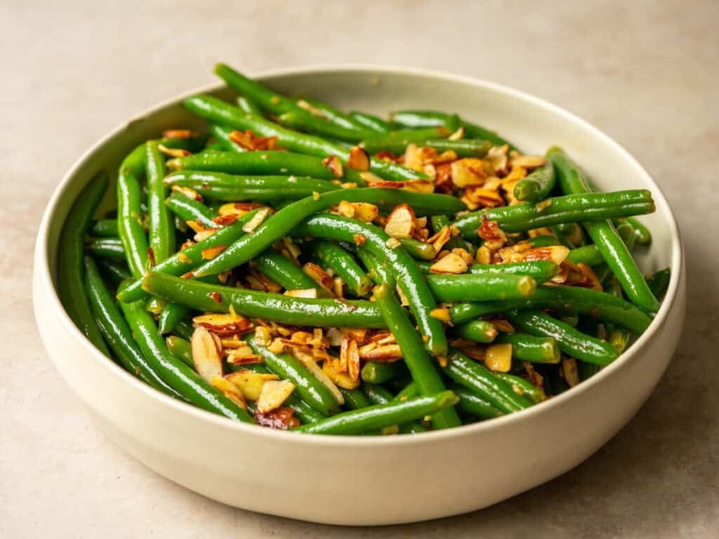 Green beans almondine in a white bowl