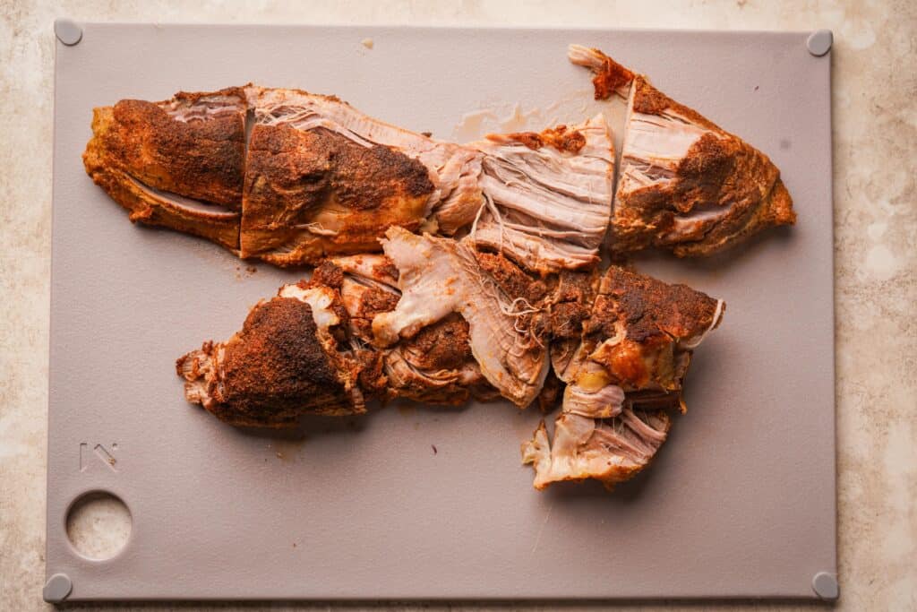 Cooked pork tenderloins on a cutting board cut into smaller sections
