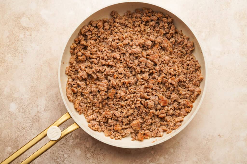 A frying pan with crumbled breakfast sausage inside
