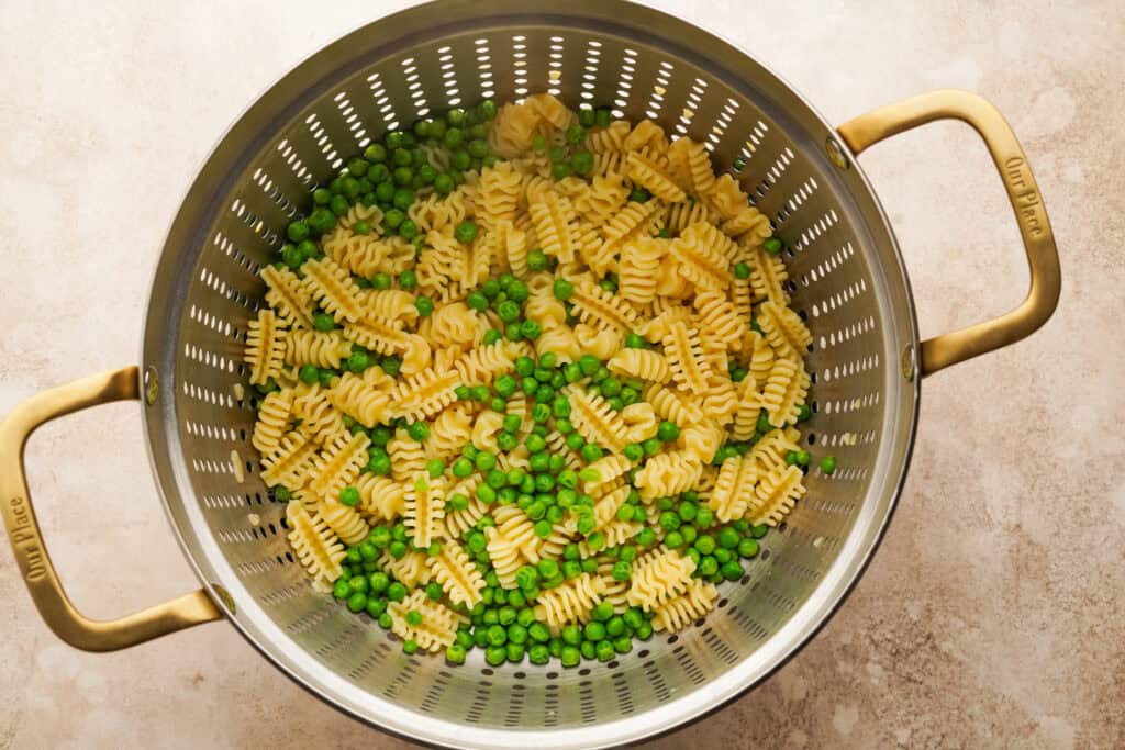 pasta and peas in a strainer