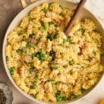 an above view image of pasta with pancetta and peas in a pan