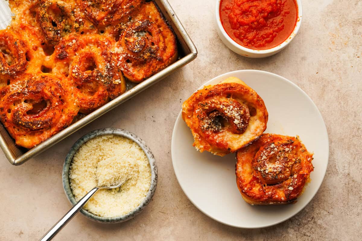 two pinwheels on a plate with the baking dish next to it