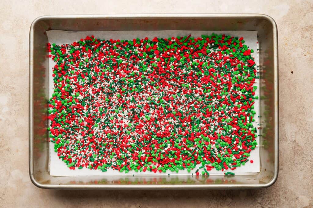 A baking pan filled with a layer of christmas sprinkles