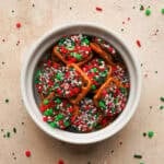 Rolo pretzel bites in a small ceramic cup with sprinkles all around the bag