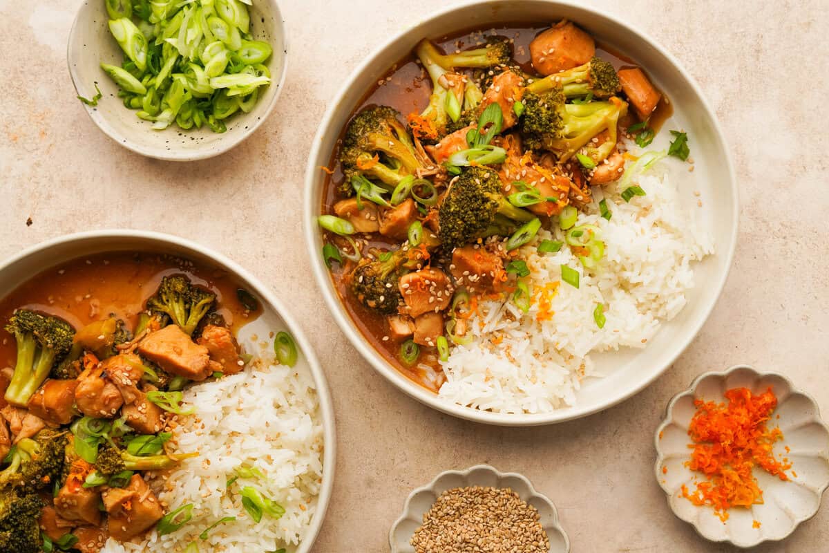 an above view photo of slow cooker orange chicken and broccoli in a bowl with rice and another bowl next to it