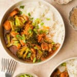 an above view photo of slow cooker orange chicken and broccoli in a bowl with rice and another bowl next to it