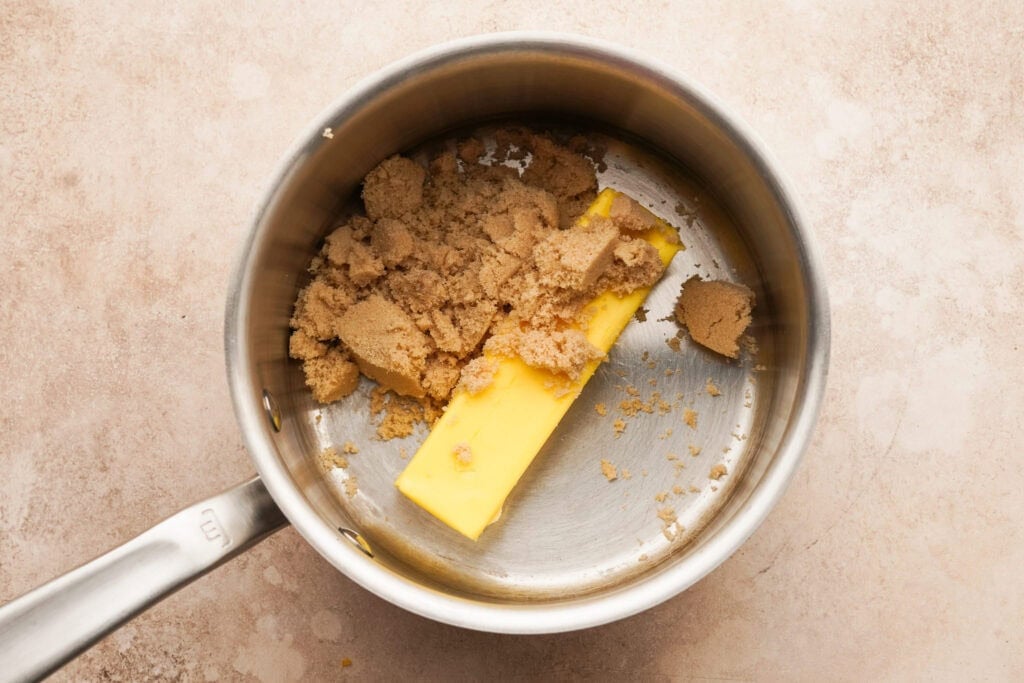 a small sauce pot with a stick of butter and brown sugar inside