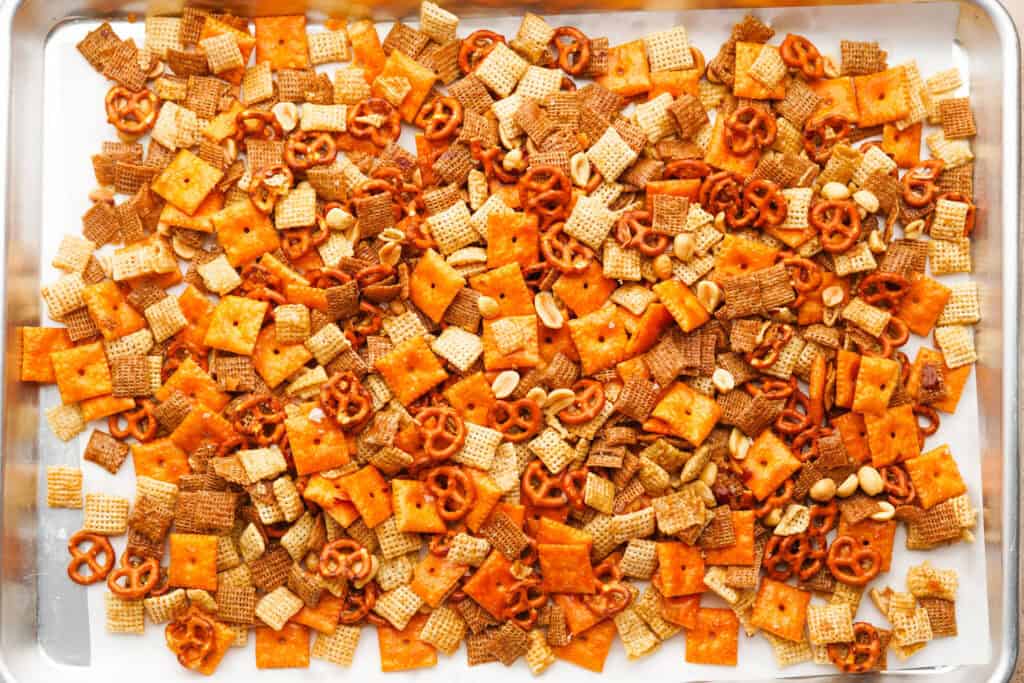 sweet and salty chex mix after it is done baking cooling on a baking sheet line wit parchment paper