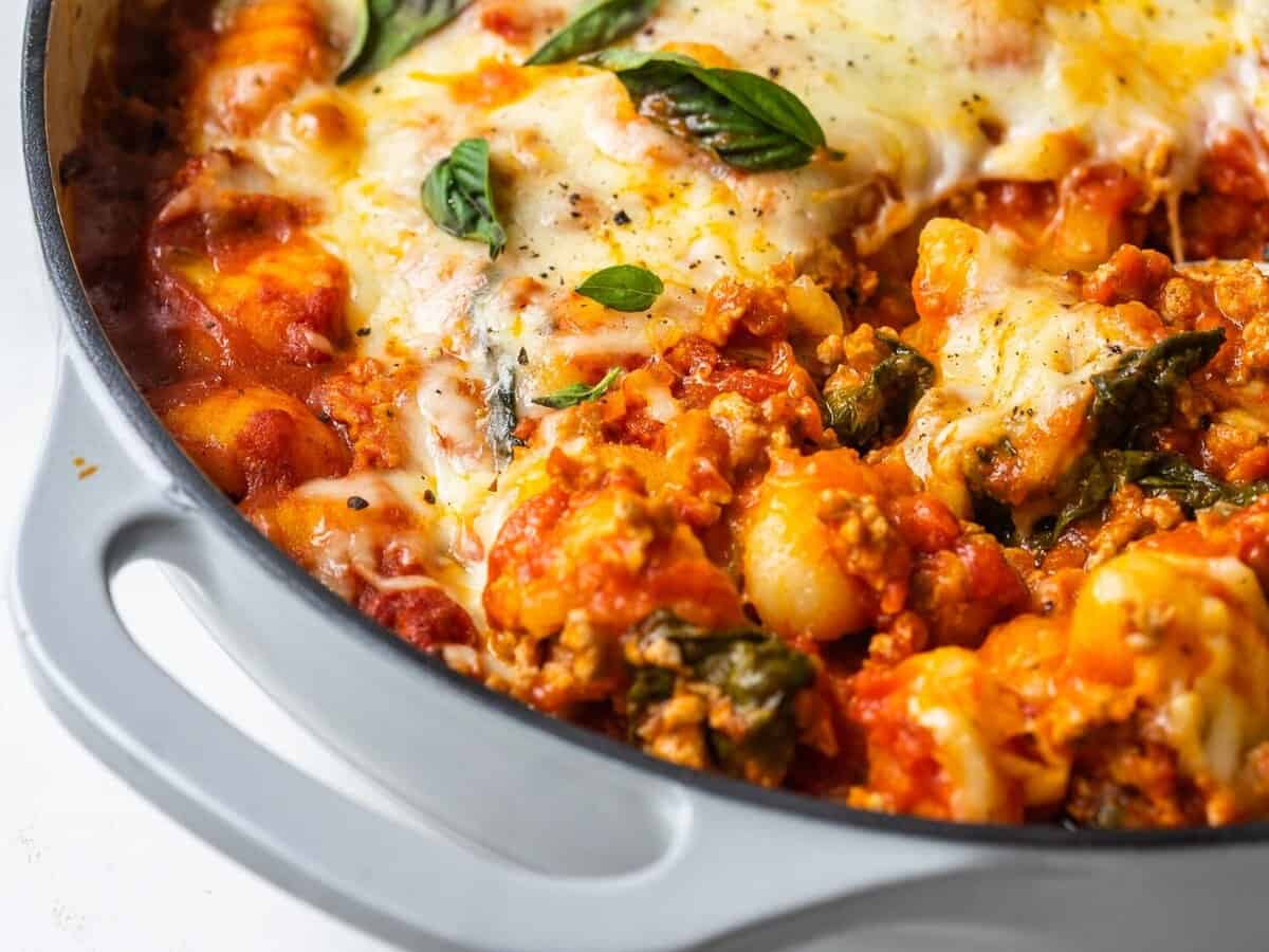 Three quarter view of gnocchi bake with basil on top