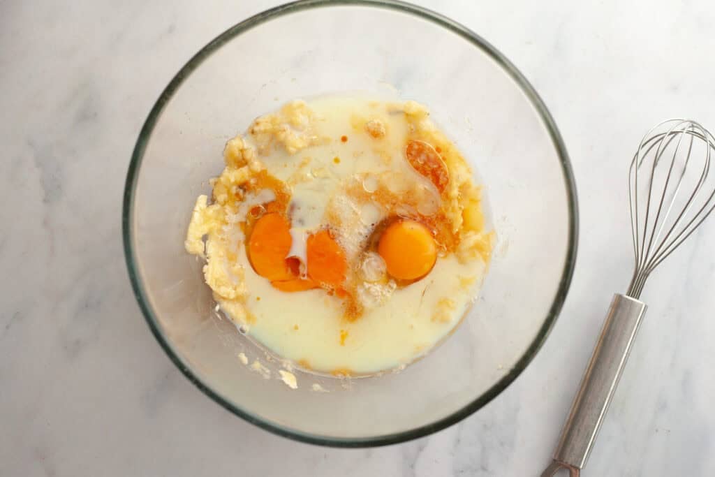mashed bananas, eggs, milk, vanilla, and brown sugar in a mixing bowl