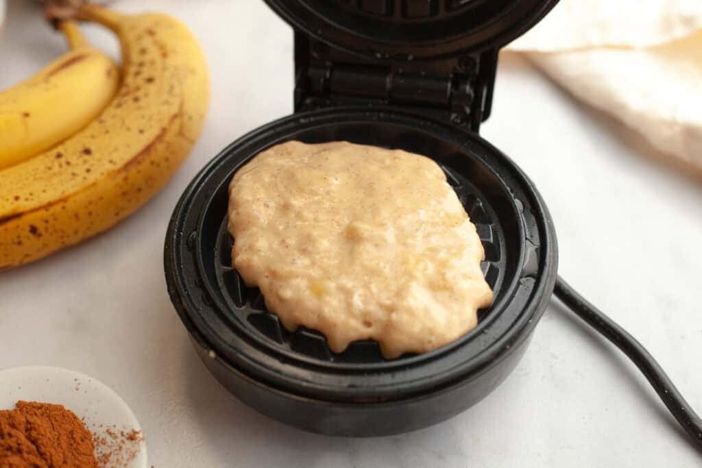 banana bread waffle batter in a mini waffle iron