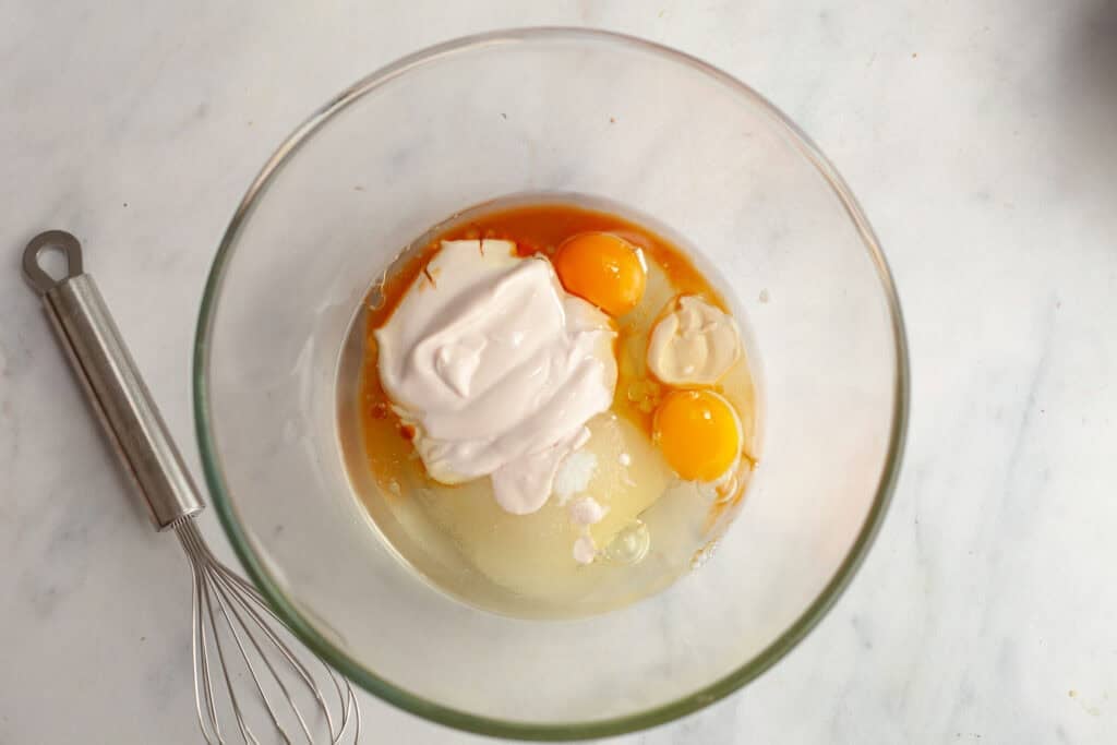 yogurt, eggs, oil, sugar, and vanilla in glass bowl