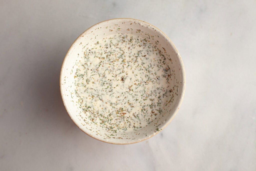 A small bowl with a mayo, herb and pepperoncini juice mixture
