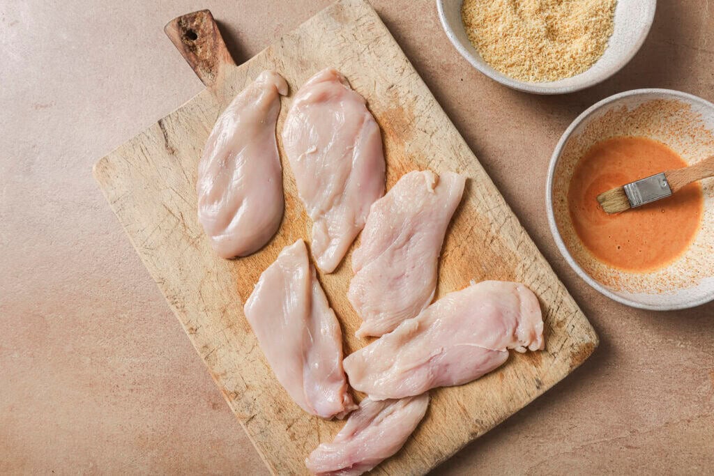 chicken being set up with mayo mixture and panko mixture