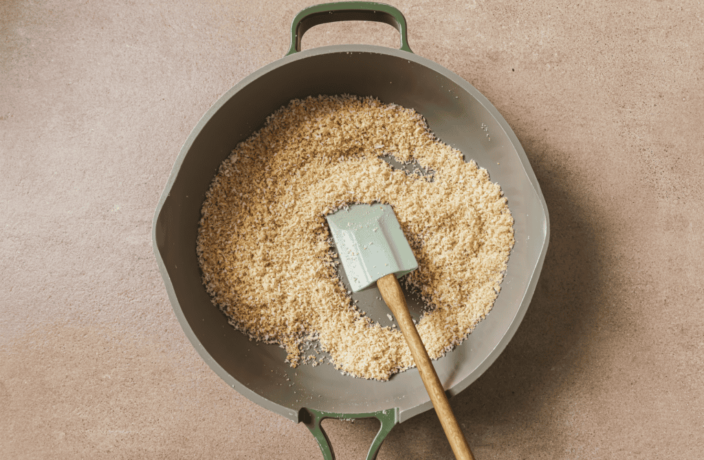 bread crumbs being roasted in a saucepan