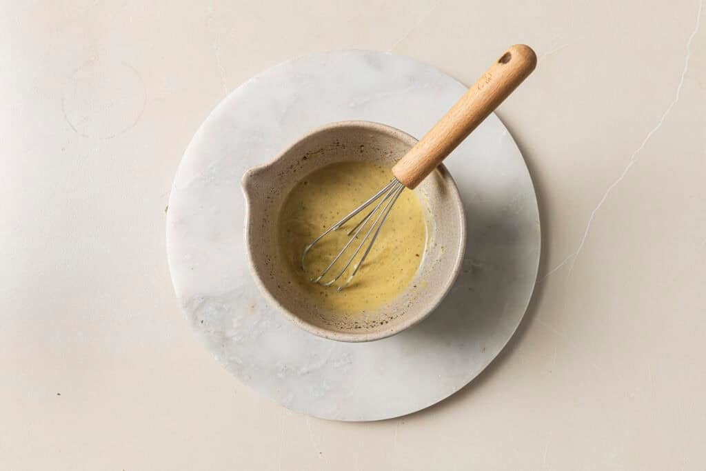 honey mustard in a bowl with a whisk