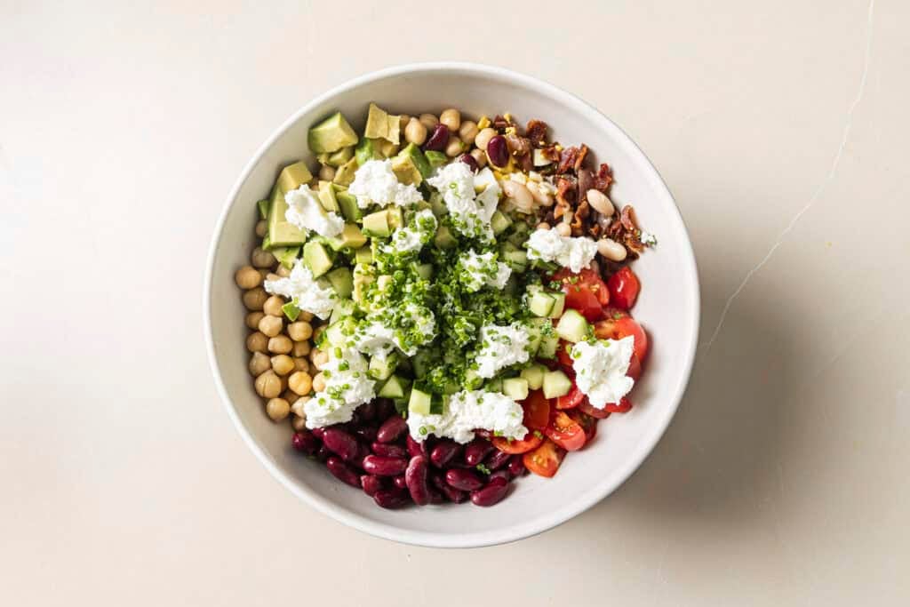 all three bean chopped cobb salad ingredients in a bowl