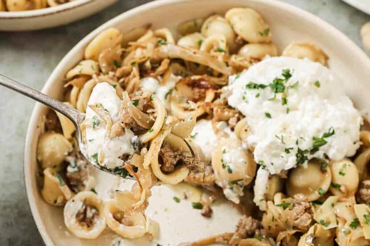 bite being taken out of sausage fennel pasta dish