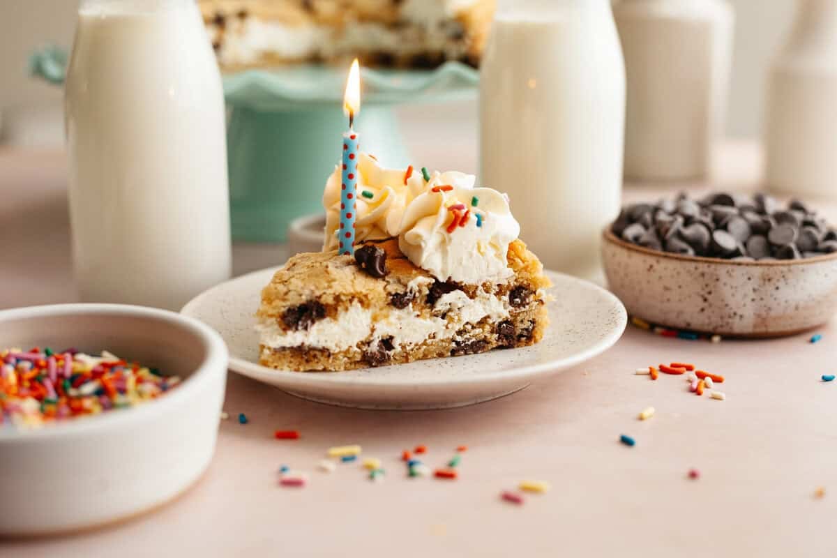a piece of layered cookie cake with a candle in it, sitting on a plate
