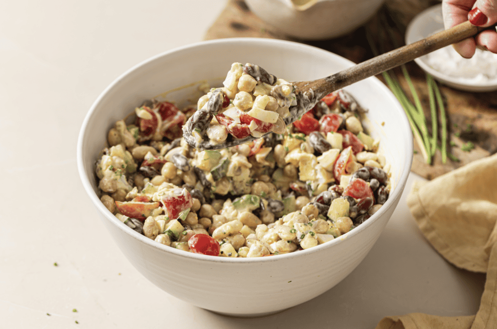 three bean chopped cobb salad in a bowl with a spoon