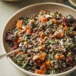 roasted beet and lentil chopped salad in a tan bowl with a spoon in it