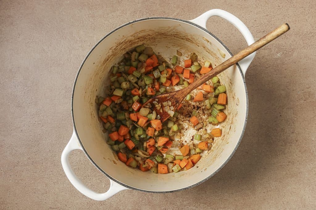 carrot, celery, and onion being sautéd in a pot