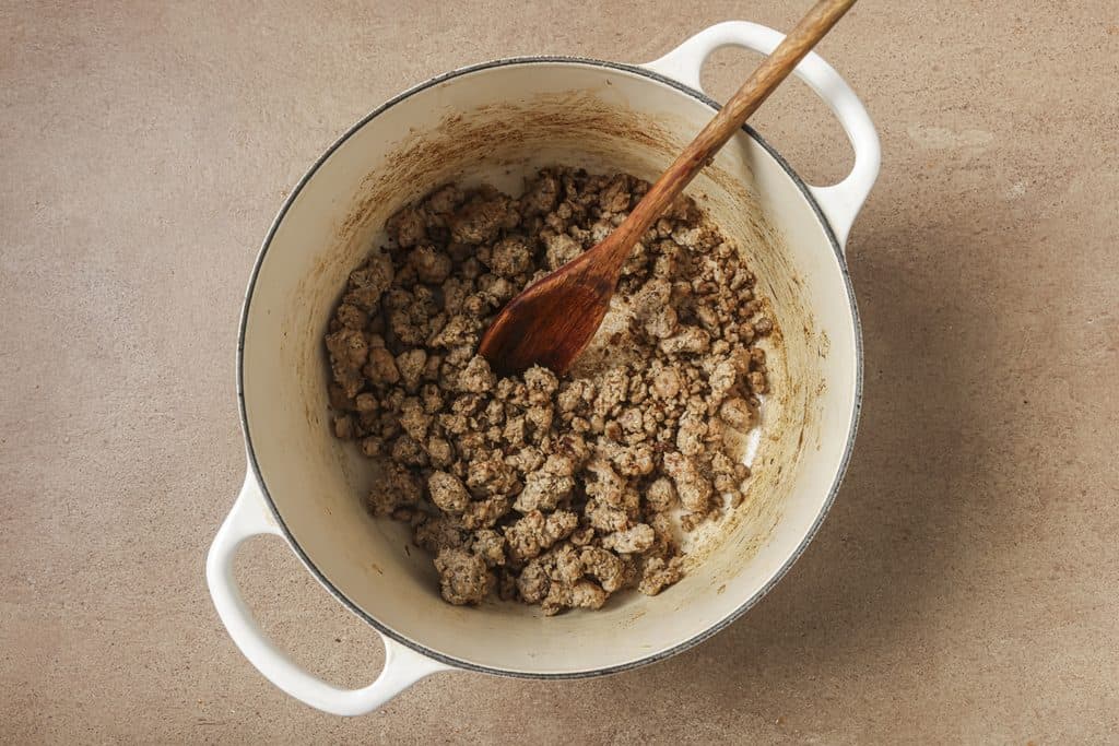 italian sausage being browned in a pot